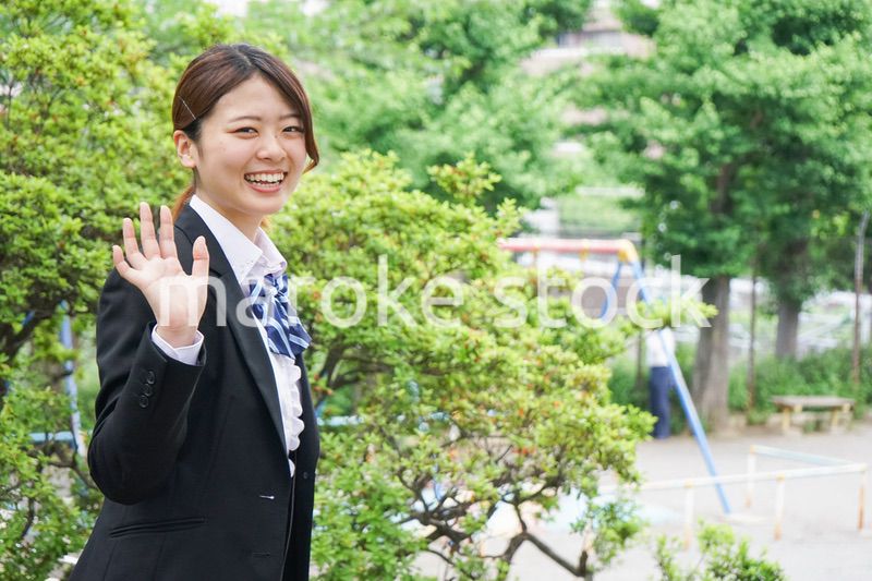 笑顔で手を振る制服姿の学生