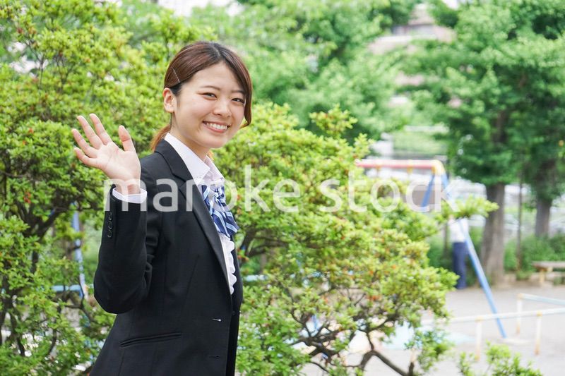 笑顔で手を振る制服姿の学生