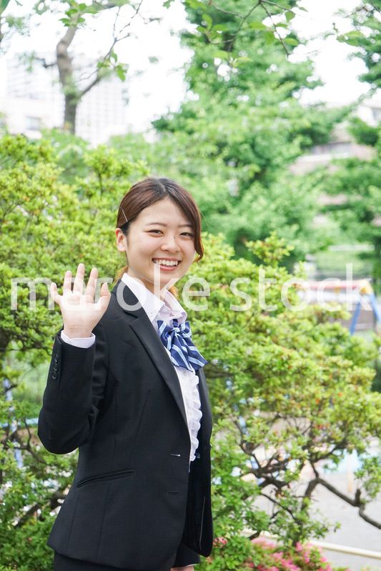 笑顔で手を振る制服姿の学生