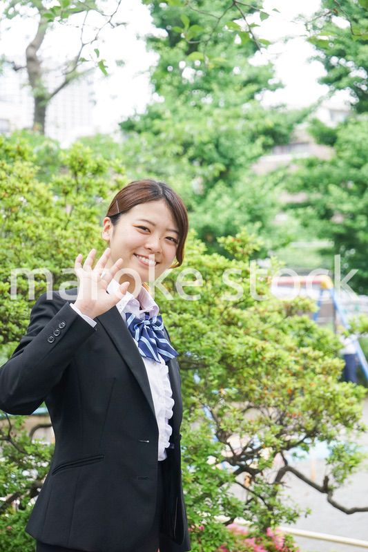 笑顔で手を振る制服姿の学生