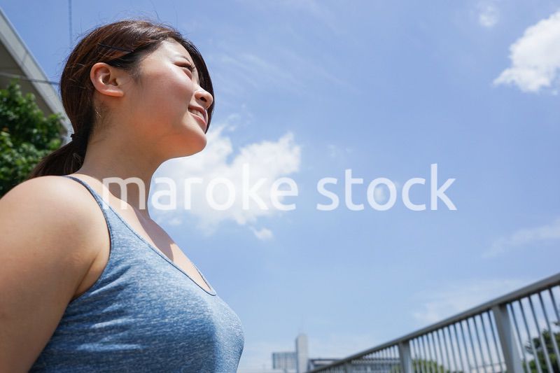 都会をランニングする若い女性