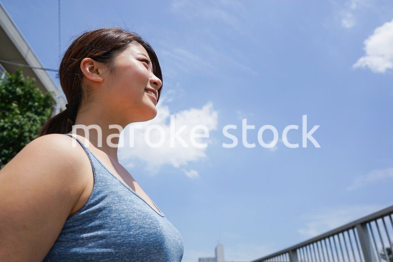 都会をランニングする若い女性