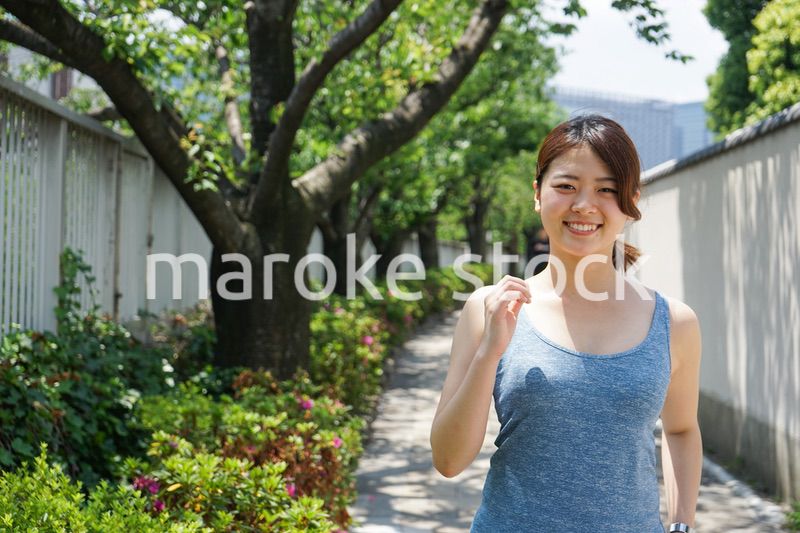 都会をランニングする若い女性