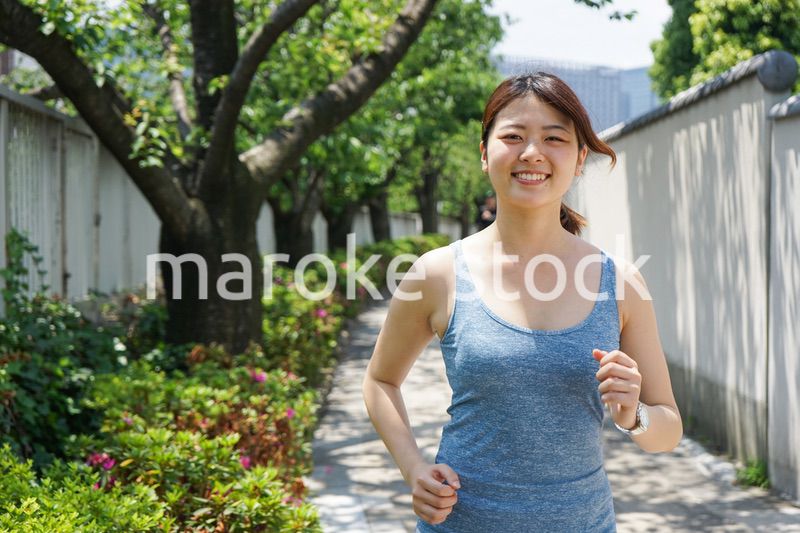 都会をランニングする若い女性