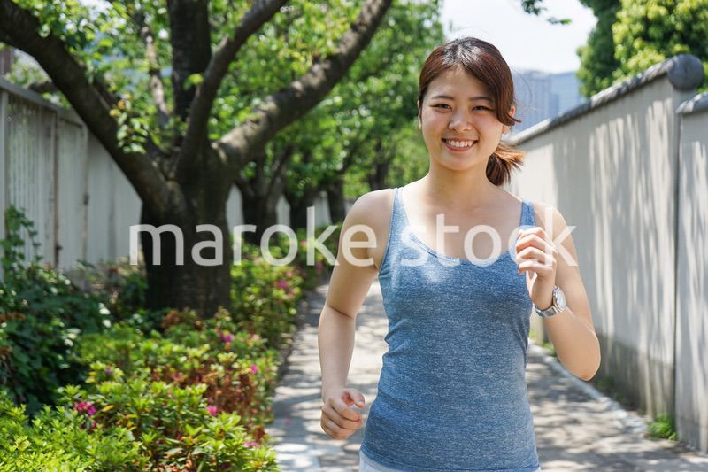 都会をランニングする若い女性