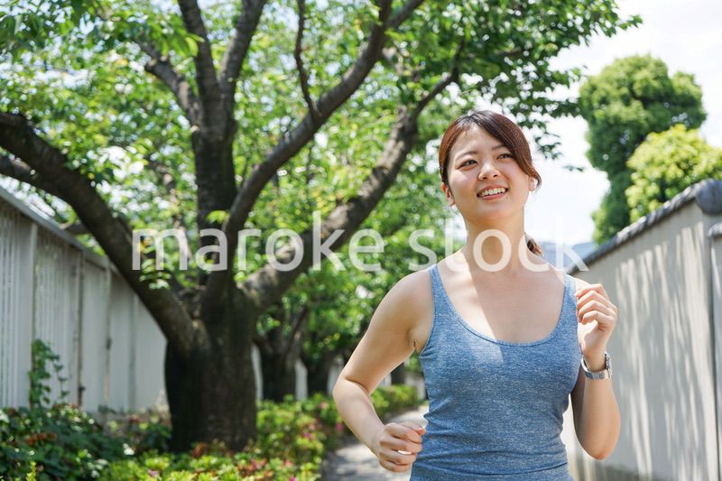 都会をランニングする若い女性