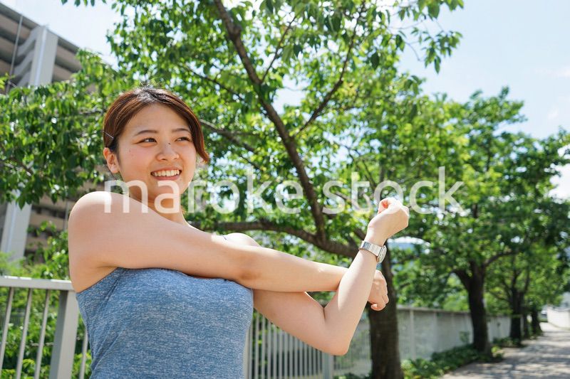 ジョギングのストレッチ準備運動をする若い女性