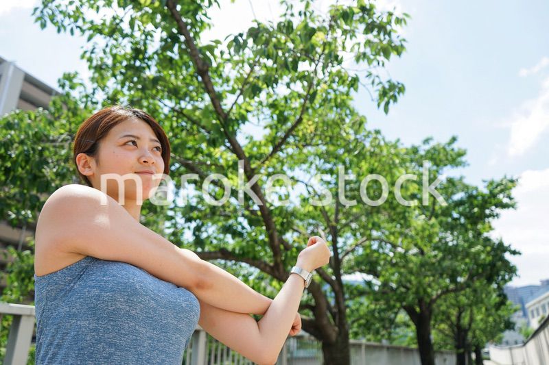 ジョギングのストレッチ準備運動をする若い女性