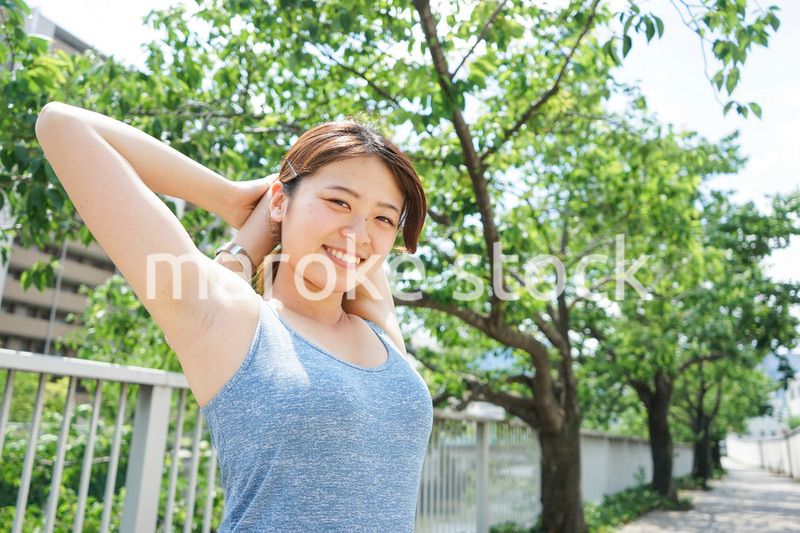 ジョギングのストレッチ準備運動をする若い女性