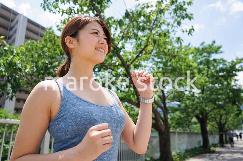 都会をランニングする若い女性