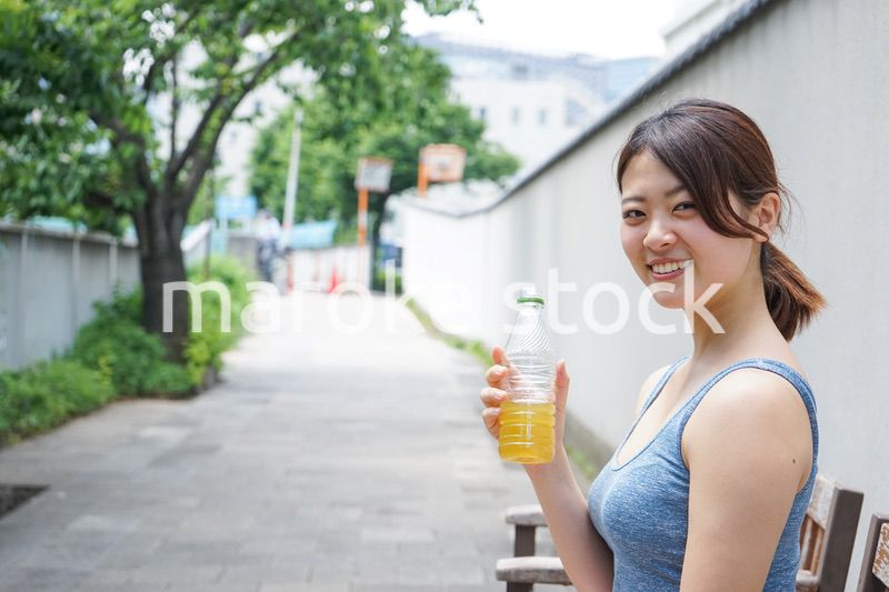 スポーツ中に水分補給をする若い女性