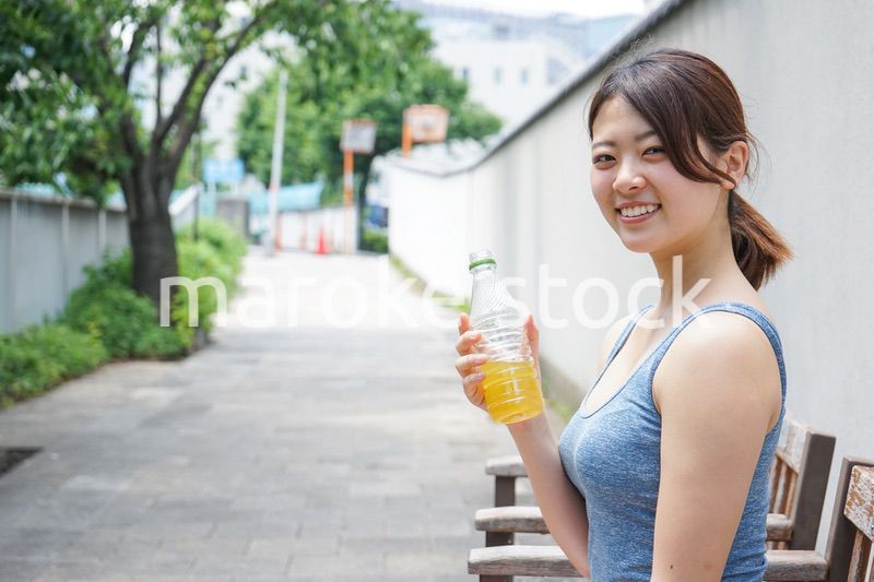 スポーツ中に水分補給をする若い女性