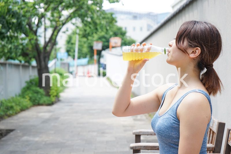 スポーツ中に水分補給をする若い女性