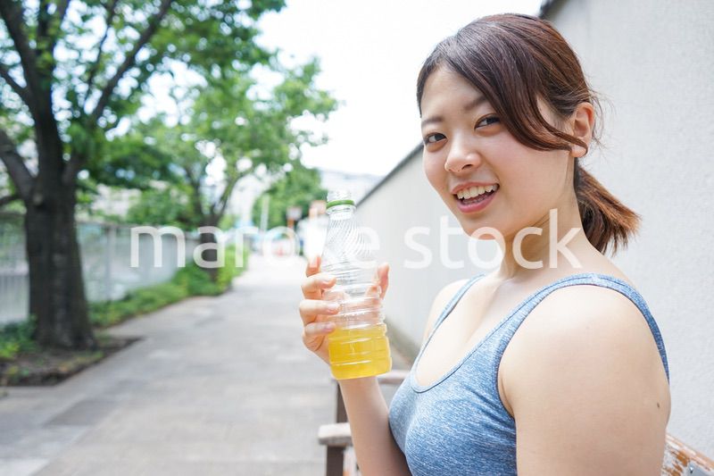 スポーツ中に水分補給をする若い女性