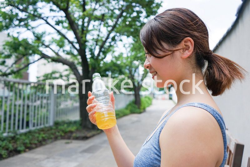 スポーツ中に水分補給をする若い女性