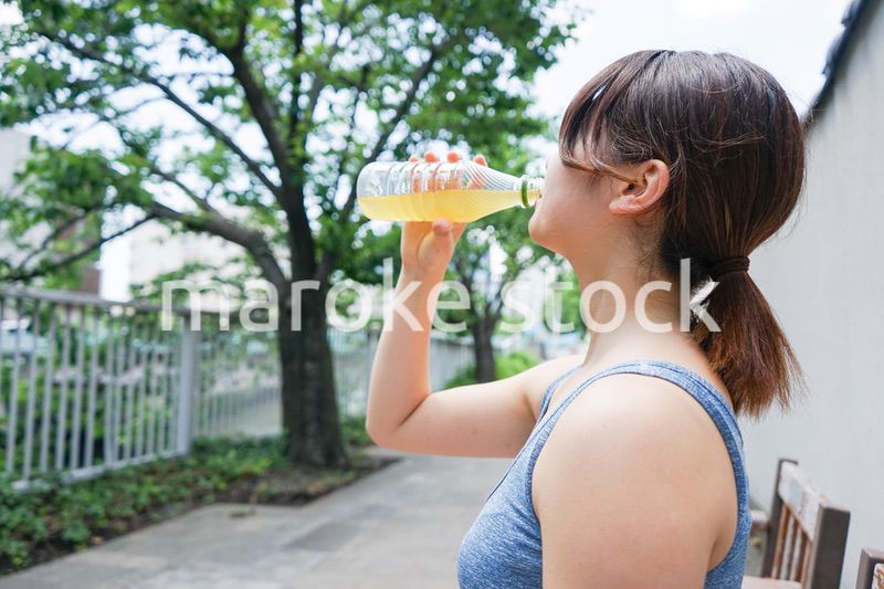 スポーツ中に水分補給をする若い女性