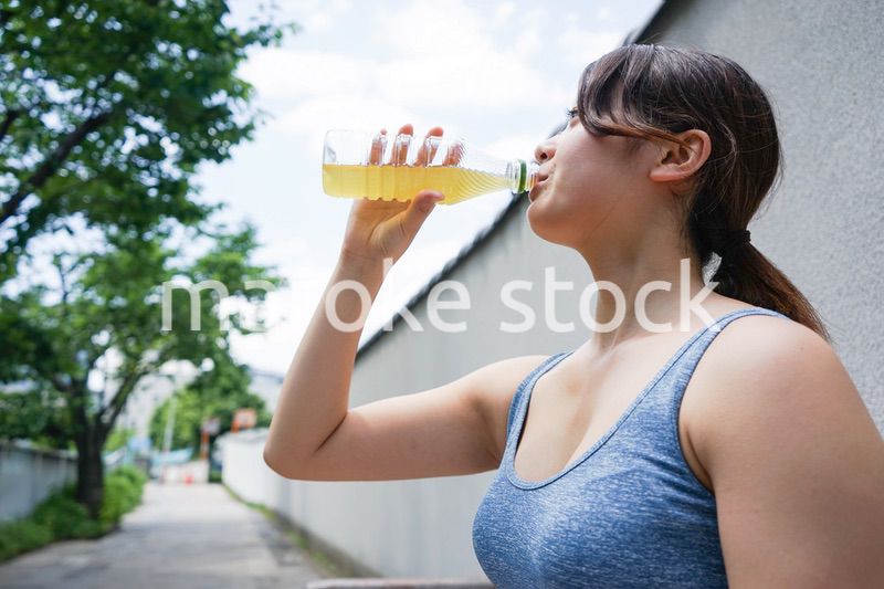 スポーツ中に水分補給をする若い女性