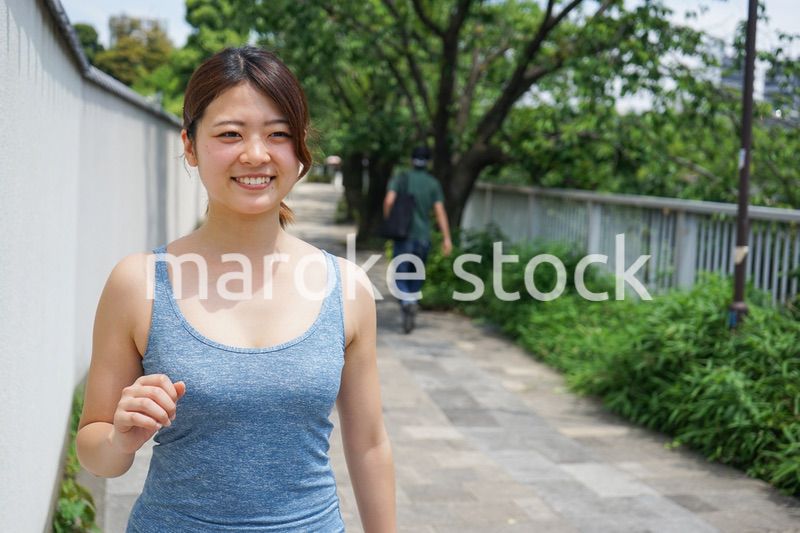 都会をランニングする若い女性