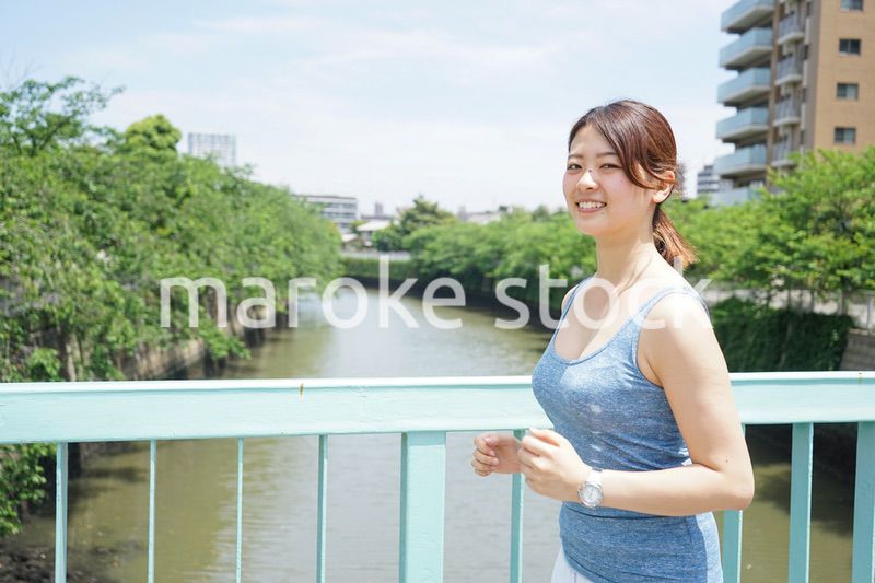 都会をランニングする若い女性