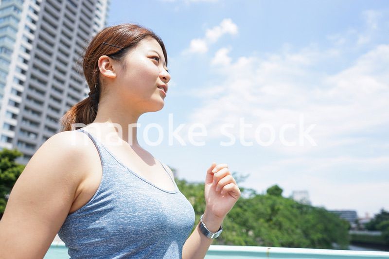 都会をランニングする若い女性