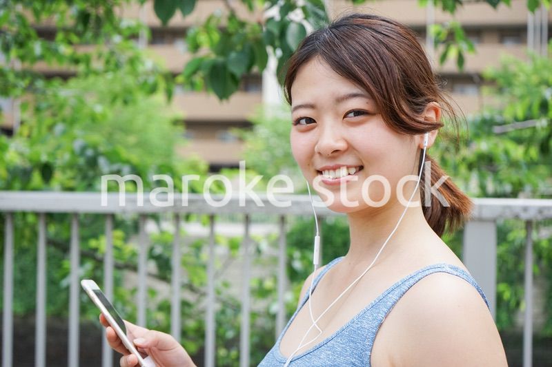 音楽を聴きながらランニングする若い女性