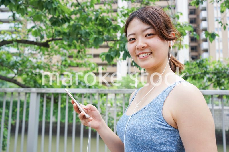 音楽を聴きながらランニングする若い女性