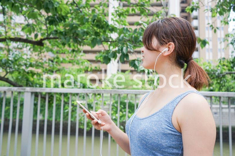 音楽を聴きながらランニングする若い女性