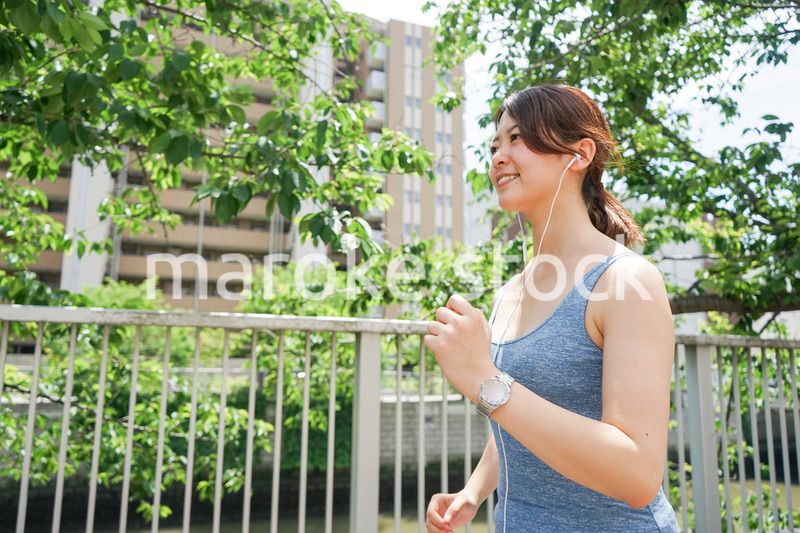 音楽を聴きながらランニングする若い女性