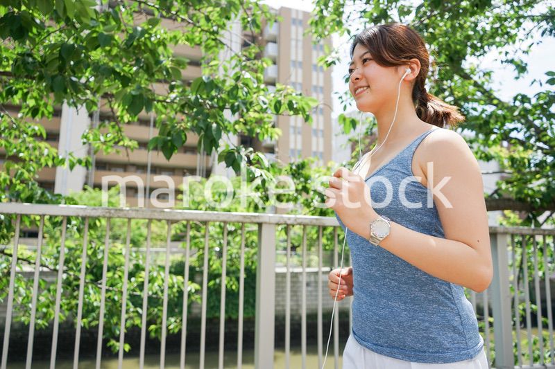 音楽を聴きながらランニングする若い女性