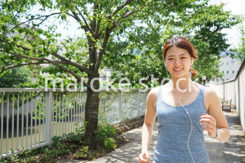 音楽を聴きながらランニングする若い女性
