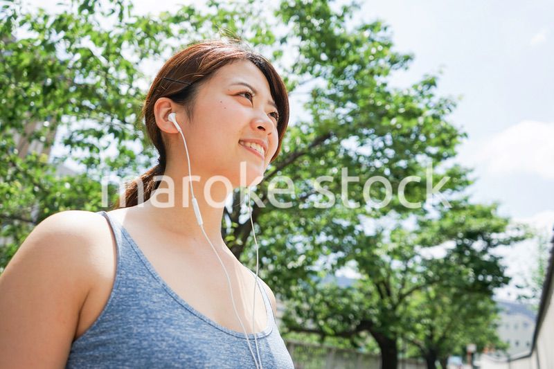 音楽を聴きながらランニングする若い女性