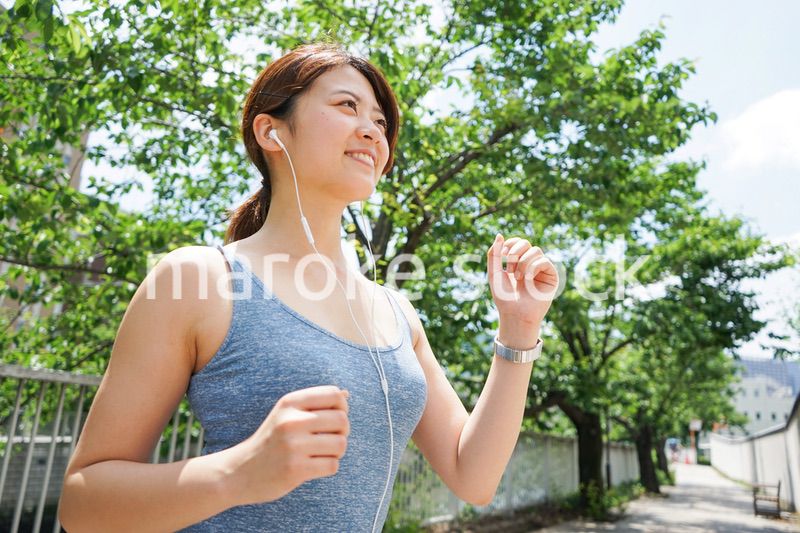 音楽を聴きながらランニングする若い女性
