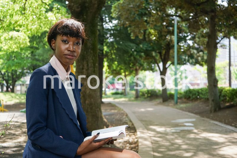 公園で読書をする黒人女性