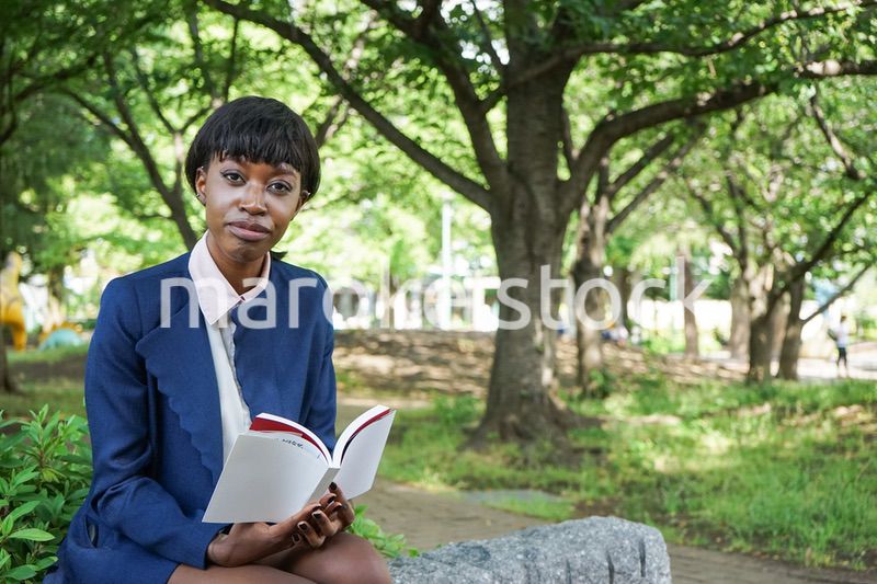 公園で読書をする黒人女性