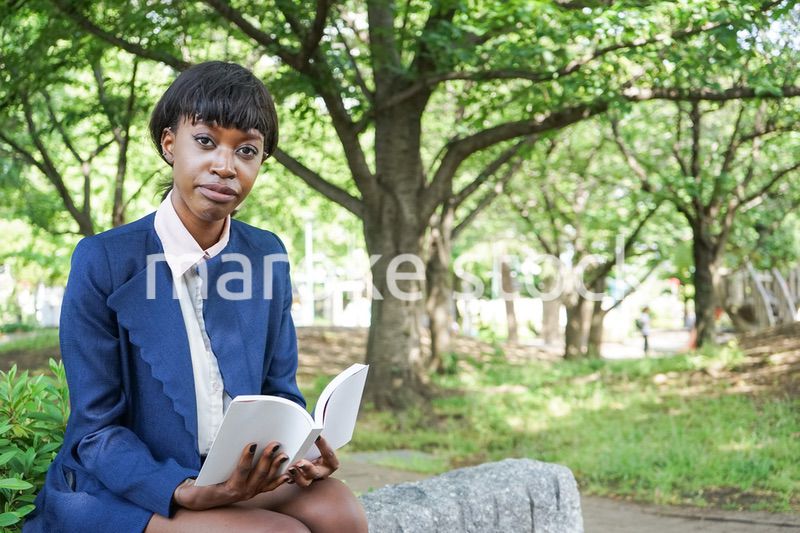 公園で読書をする黒人女性