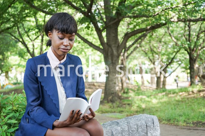 公園で読書をする黒人女性