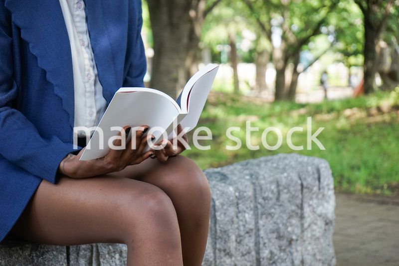 公園で読書をする黒人女性