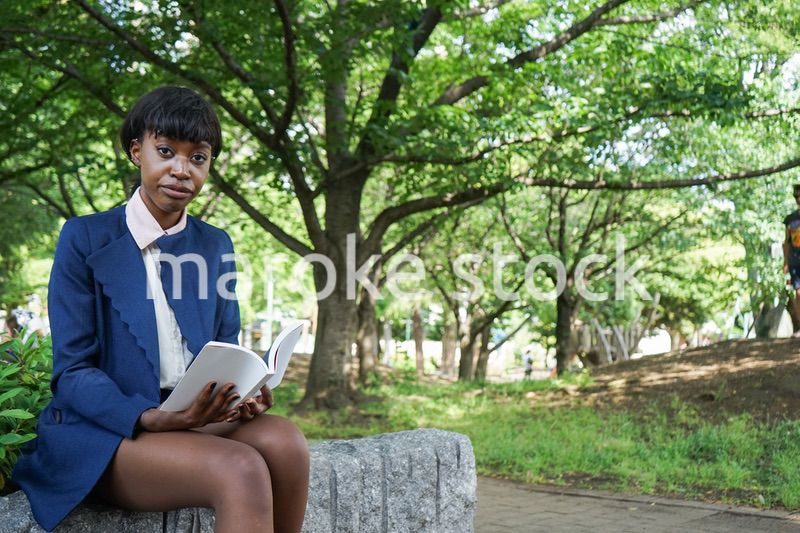 公園で読書をする黒人女性
