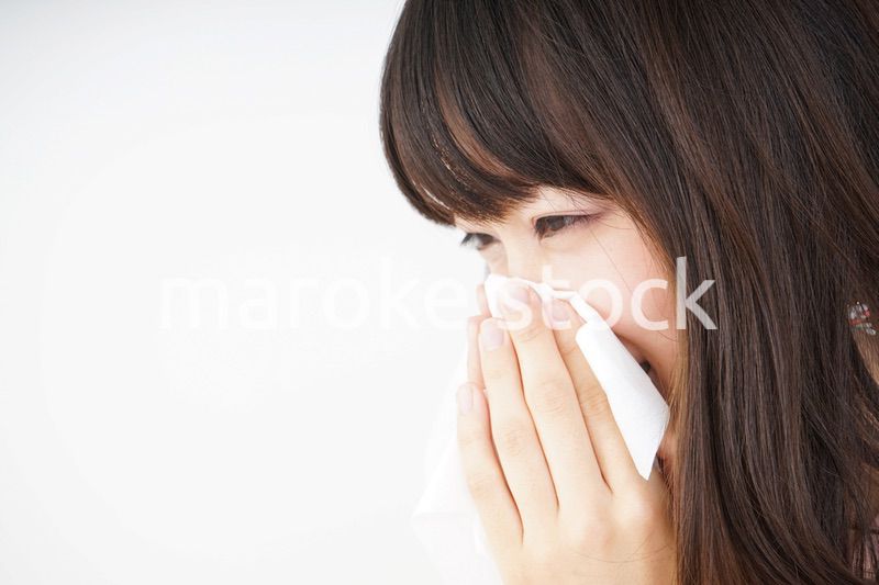 鼻をかむ若い女性