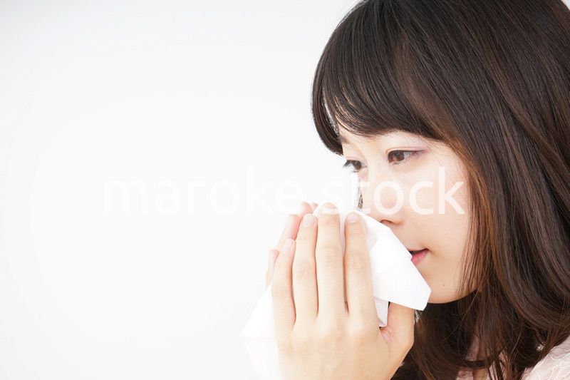 鼻をかむ若い女性
