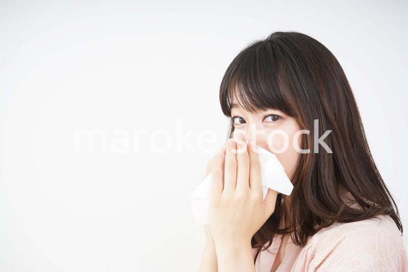 鼻をかむ若い女性