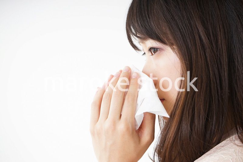 鼻をかむ若い女性