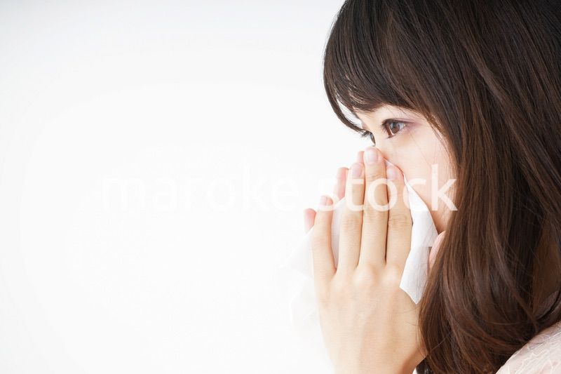 鼻をかむ若い女性