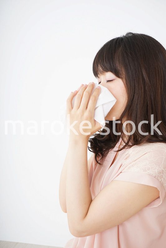 鼻をかむ若い女性