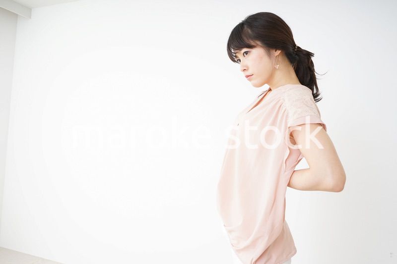 腰の痛みを感じる若い女性