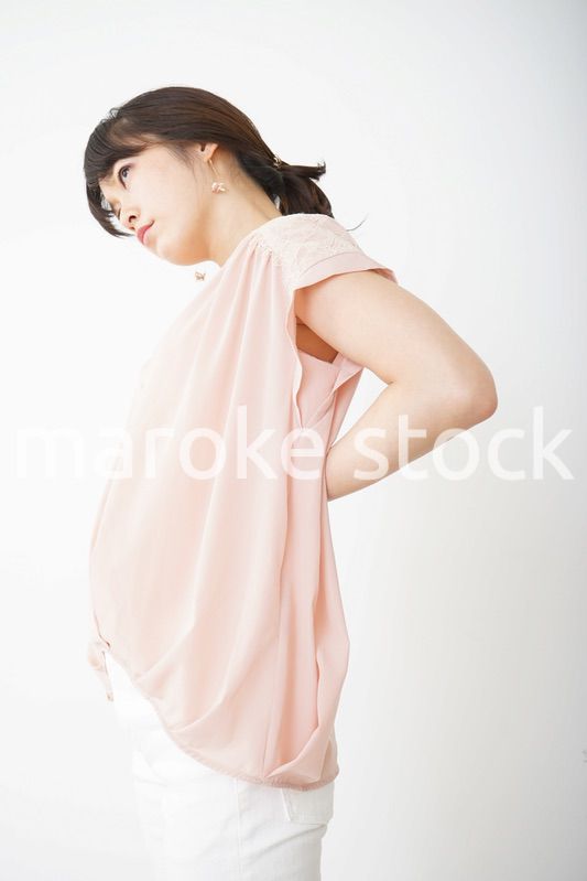 腰の痛みを感じる若い女性