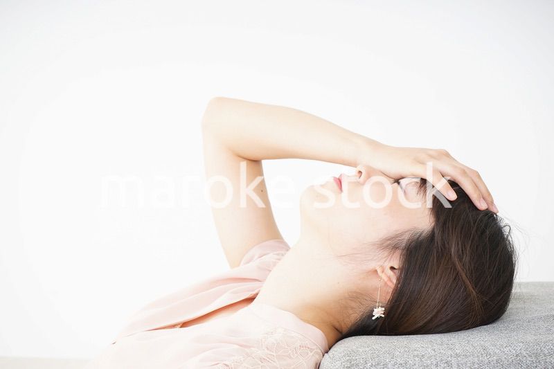 体調不良で横たわる若い女性