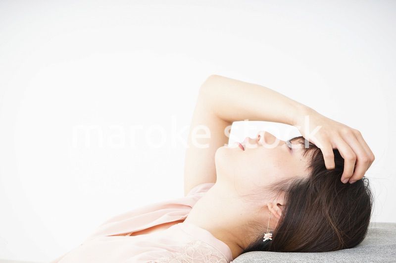体調不良で横たわる若い女性