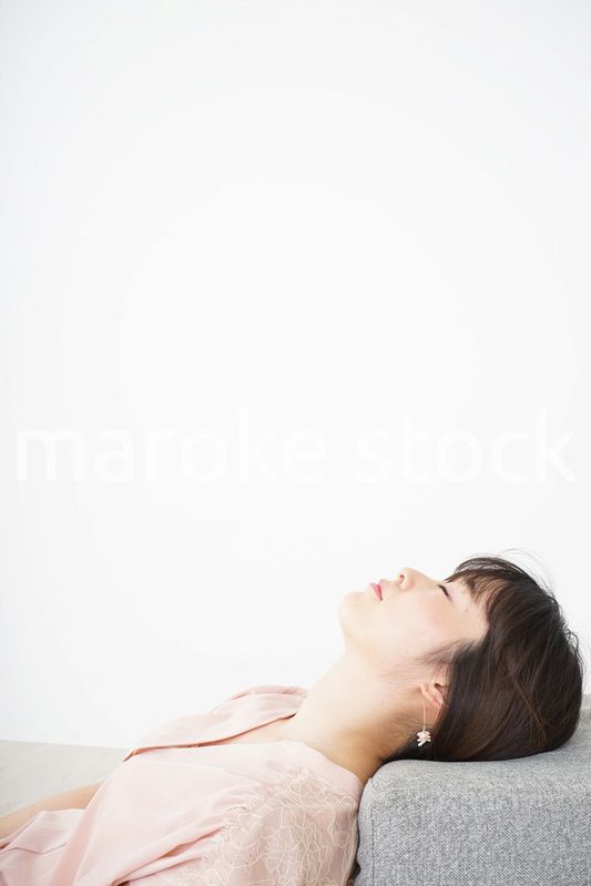 体調不良で横たわる若い女性