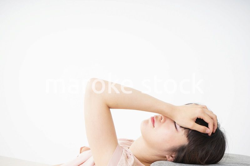 体調不良で横たわる若い女性